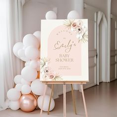 a baby shower sign sitting on top of a wooden easer next to balloons in the background