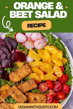 a salad with oranges, beets and other vegetables on it in a white bowl