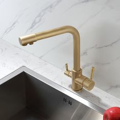 an apple sitting on top of a kitchen sink next to a faucet and counter