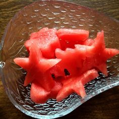 slices of watermelon in a glass bowl on a wooden table