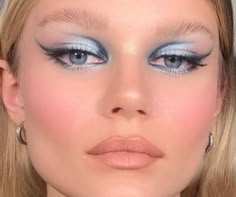 a blonde woman with blue eyes and makeup