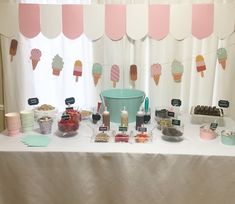 a table topped with lots of desserts and ice cream cones on top of it