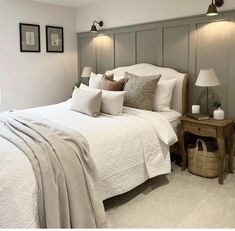 a white bed sitting in a bedroom next to two framed pictures on the wall above it