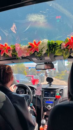 the interior of a car with flowers on the windshield