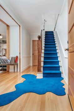 a blue rug on the floor in front of a stair case