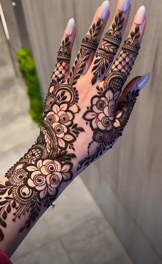 a woman's hand with henna tattoos on it