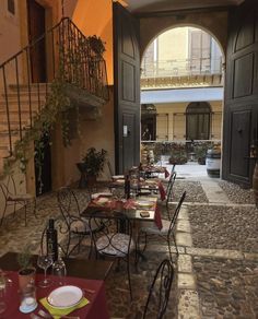 an outdoor dining area with tables and chairs in front of the entrance to a building