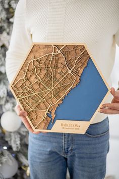 a woman holding a wooden map of barcelona