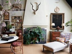 a living room filled with furniture and a fire place in front of a wall mounted deer head