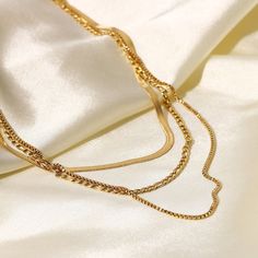 This Layered Chain Necklace combines multiple 18k gold-plated strands for a chic, multi-layered look. It’s an effortlessly stylish piece, adding depth and texture to any outfit, suitable for both casual and formal occasions. Figaro Chain Necklace, Layered Chain, Layered Chain Necklace, 18k Gold Necklace, Snake Chain Necklace, Layered Necklace Set, Layered Chains, Necklace Minimalist, Gold Necklace Women