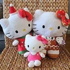 two hello kitty stuffed animals sitting next to each other on a wicker chair,