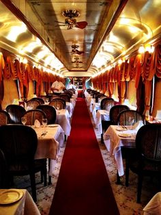 an empty dining car on a train with red carpet