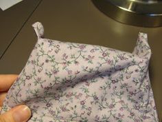 a person is holding a cloth with flowers on it and the fabric has been folded up