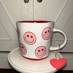 a coffee cup with hearts on it sitting on a table