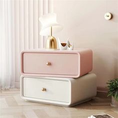 two pink and white dressers sitting next to each other