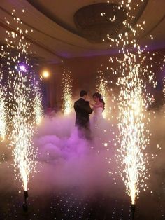 a bride and groom are surrounded by fireworks