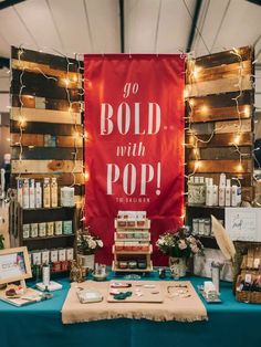 a table with a sign that says go bold with pop on it, surrounded by other items