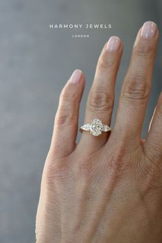 a woman's hand with a diamond ring on top of her left hand and the words harmony jewels written below it