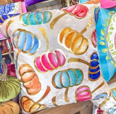 many colorful pillows are stacked on top of each other