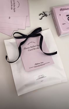 there is a bag with a ribbon on it next to some cards and other items