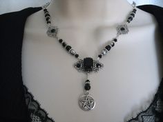 "This beautiful necklace has black Czech glass beads, pewter silver accent beads, silver plated filigree accents, black rhinestones, silver plated filigree pendant with black faceted glass setting and a pewter silver pentacle. 18\" long. Toggle clasp." Gothic Black Beads Jewelry For Halloween, Gothic Black Beads Halloween Jewelry, Spiritual Silver Onyx Beaded Necklaces, Gothic Dangle Necklaces For Jewelry Making, Gothic Metal Jewelry With Black Beads, Gothic Silver Necklaces For Festival, Gothic Silver Jewelry With Black Beads, Gothic Black Beaded Metal Jewelry, Gothic Silver Wire Wrapped Jewelry