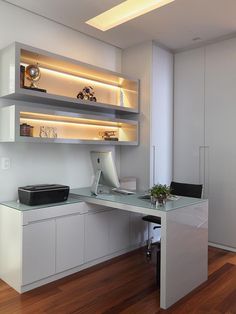 a white desk and shelves in a room with wood floors, lighting above the desk