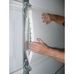 a man is holding the door handle on a white door with metal bars attached to it