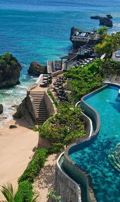 an outdoor swimming pool next to the ocean