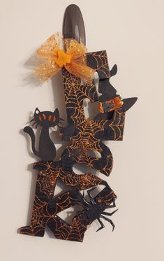 an orange and black halloween decoration hanging on a wall next to a pair of scissors