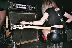 a woman sitting on the floor playing an electric guitar