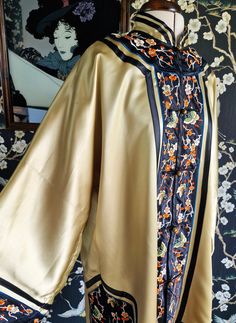 A gorgeous Chinese silk embroidery kimono robe, dating to the late 1940s. This is a great gold colour, eddging towards chartreuse in certain lights. It is lined in the same colour, but in rayon. It fastens with round brass buttons, has wide long sleeves and side vents. Edged in silk bands with fine silk embroidery of butterflies and flowers. Original label reads Dunhuang, Made in China. Nape to hem 36.5" Chest 46" Condition wise, the odd fine brushing to the silk and very faint marks only visibl Vintage Kimono With Floral Embroidery, Traditional Embroidered Kimono For Tea Ceremony, Ceremonial Vintage Kimono, Embroidery Kimono, Dunhuang, Embroidered Robes, Embroidered Kimono, Pajama Robe, Womens Robes