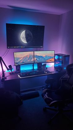 three computer monitors sitting on top of a desk in front of a large flat screen tv