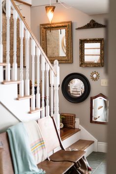 the hallway is decorated with antique mirrors and wooden benches, along with decorative wall hangings