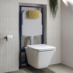 a white toilet sitting in a bathroom next to a plant