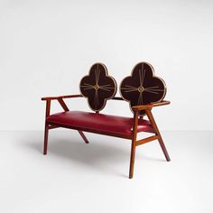 a wooden bench with two heart shaped cushions on it's back and seat cushion