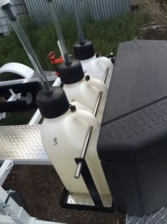 two black and white tanks sitting on top of a trailer