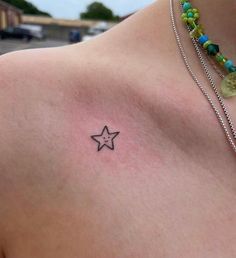 a woman with a small star tattoo on her chest