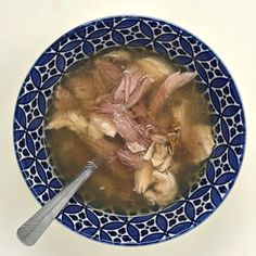 a blue and white bowl filled with soup