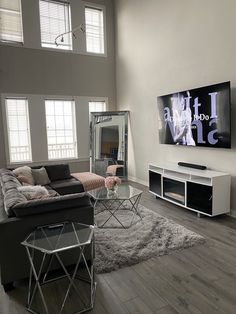 a living room filled with furniture and a flat screen tv mounted to the side of a wall