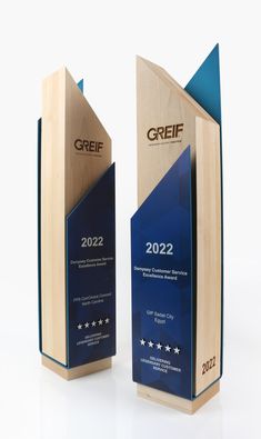 two wooden award plaques with blue and white designs on the sides, one is for creff