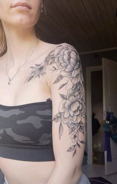 a woman with a flower tattoo on her arm and chest is looking off to the side