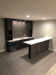 an empty kitchen with dark wood cabinets and white counter tops, along with tile flooring