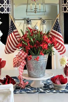 a patriotic centerpiece with red, white and blue flowers in a bucket on a table