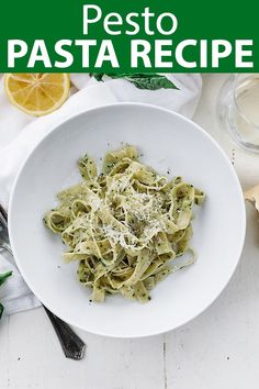 a white bowl filled with pesto pasta on top of a table