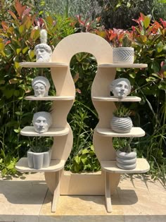 a wooden shelf with some white vases on it