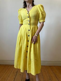 Gorgeous vintage trachten folk dress in beautiful bright yellow. Made out of cotton and linen blend. Fitted silhouette with accentuated waist and exaggerated puff sleeves.  - marked size: 34 - best fits size S  - 55% linen 45% cotton - great vintage condition MEASUREMENTS *taken seam to seam. not doubled, taken flat Shoulders: 31 cm | 12.2" Bust: 42 cm | 16.5" Waist: 34 cm | 13.3" Sleeve length:  32 cm | 12.9" Length: 112 cm | 44" For reference, our model is size S and is 5"2 tall  SHIPPING Sent Yellow Fitted Linen Dress, Fitted Yellow Linen Dress, Vintage Yellow Puff Sleeve Dress, Dirndl Dress, Folk Dresses, Curated Vintage, Vintage Yellow, Linen Blend, Dress Clothes For Women