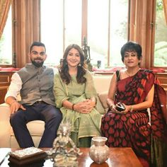 two women and a man sitting on a couch