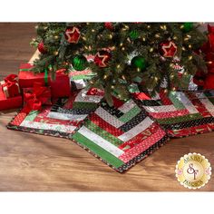 a christmas tree with presents under it on the floor