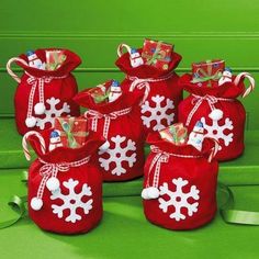 red bags with white snowflakes and candy canes are sitting on a green surface