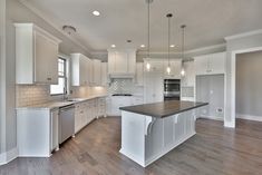 an empty kitchen with white cabinets and wood floors is pictured in this image from the inside